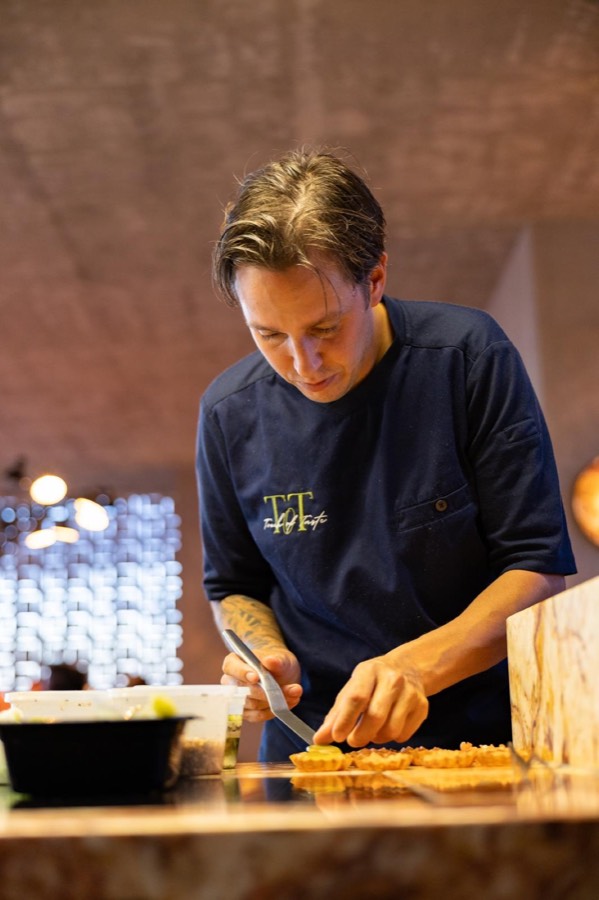 Chef René plating a dish in the kitchen